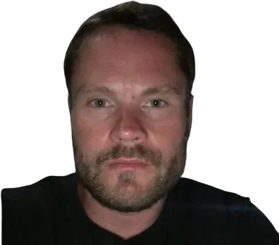 Lähikuva valkoihoisesta miehestä, jolla on lyhyet hiukset ja parta, mustalla taustalla.